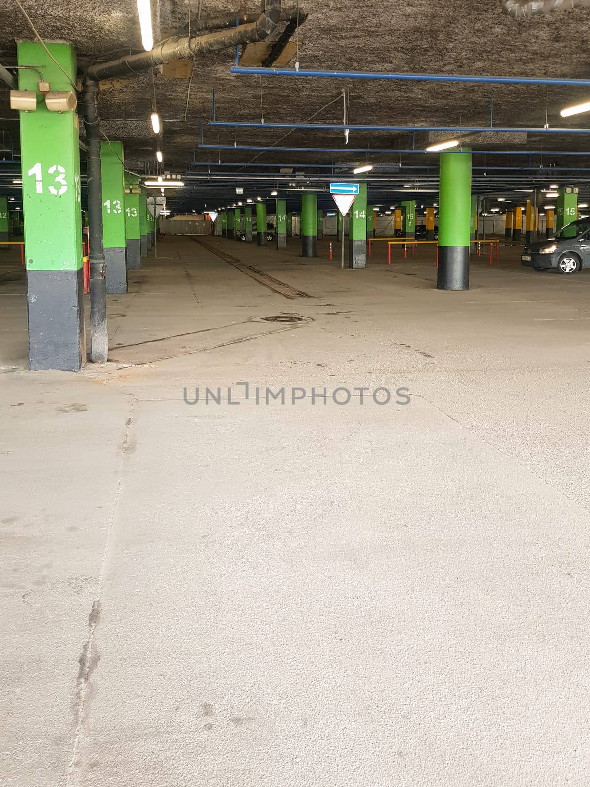 Underground Parking with poles with markings for cars in the shopping center, a place for text at the bottom by claire_lucia