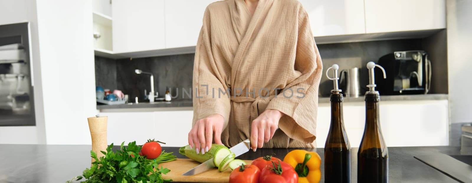 Close up portrait of female hands, woman wearing robe, cutting vegetables on chopping board, cooking vegan dinner, vegetarian meal for family, standing in kitchen by Benzoix