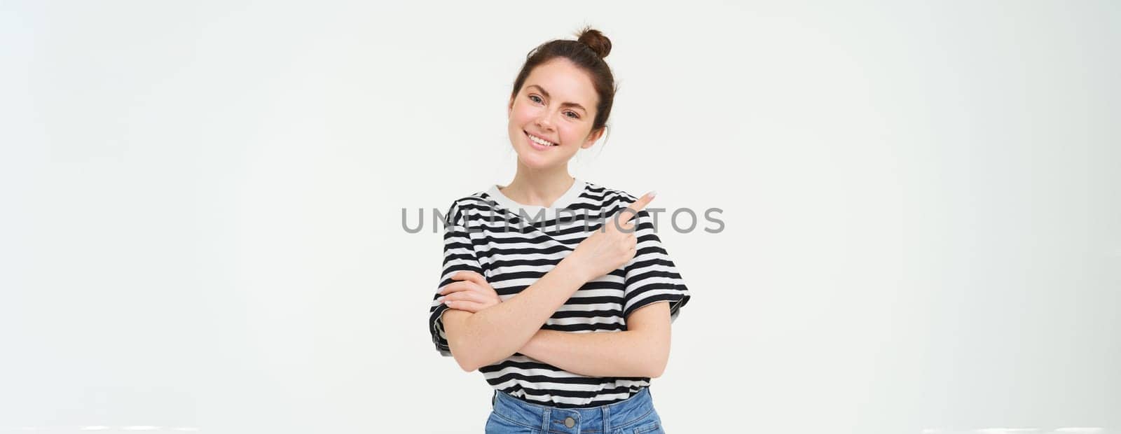 Lifestyle and advertisement concept. Young smiling woman, modern girl, pointing finger at promo, showing banner, place with text, isolated on white background by Benzoix