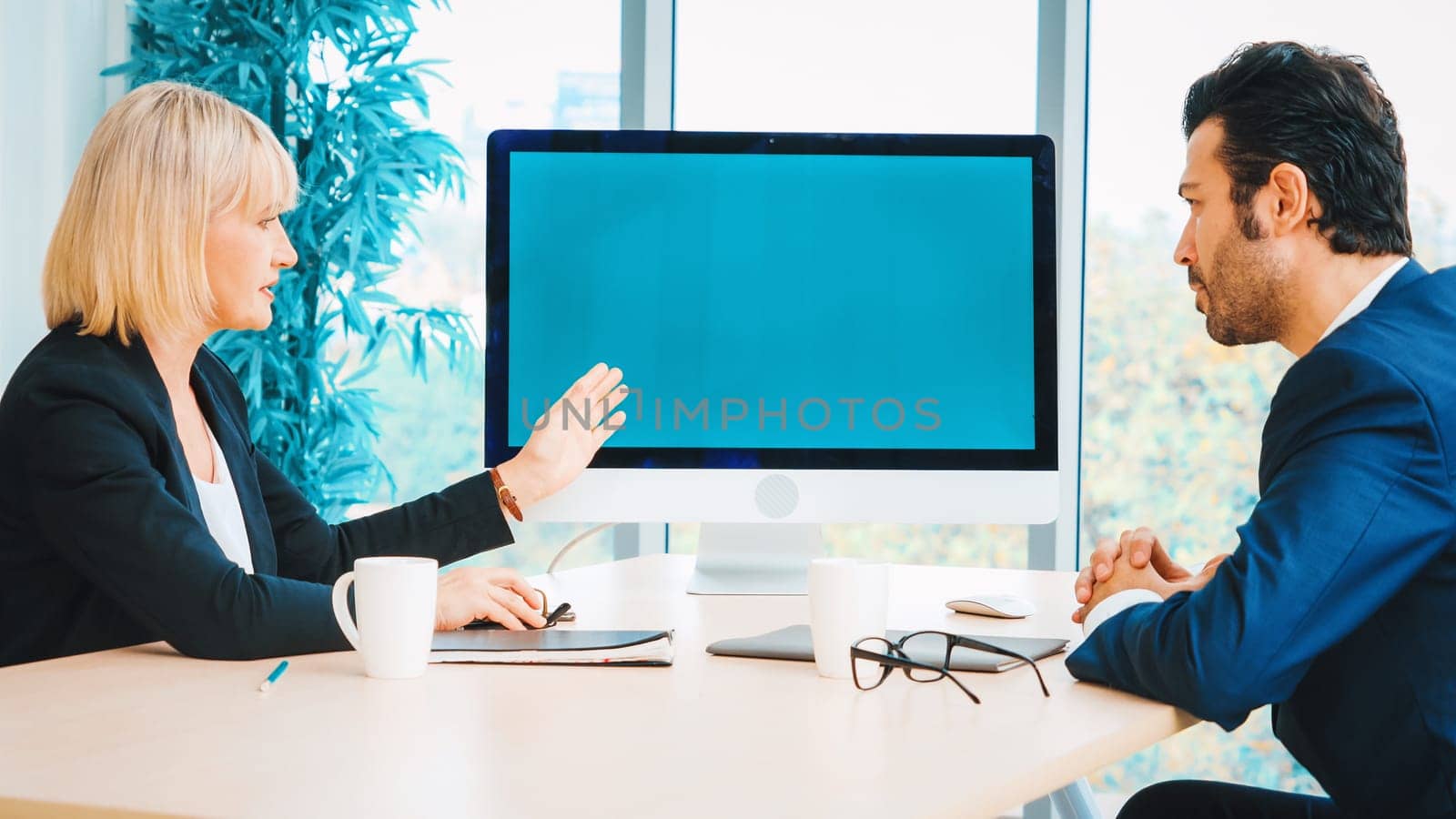 Business people in the conference room with green screen chroma key TV or computer on the office table. Diverse group of businessman and businesswoman in meeting on video conference call . Jivy