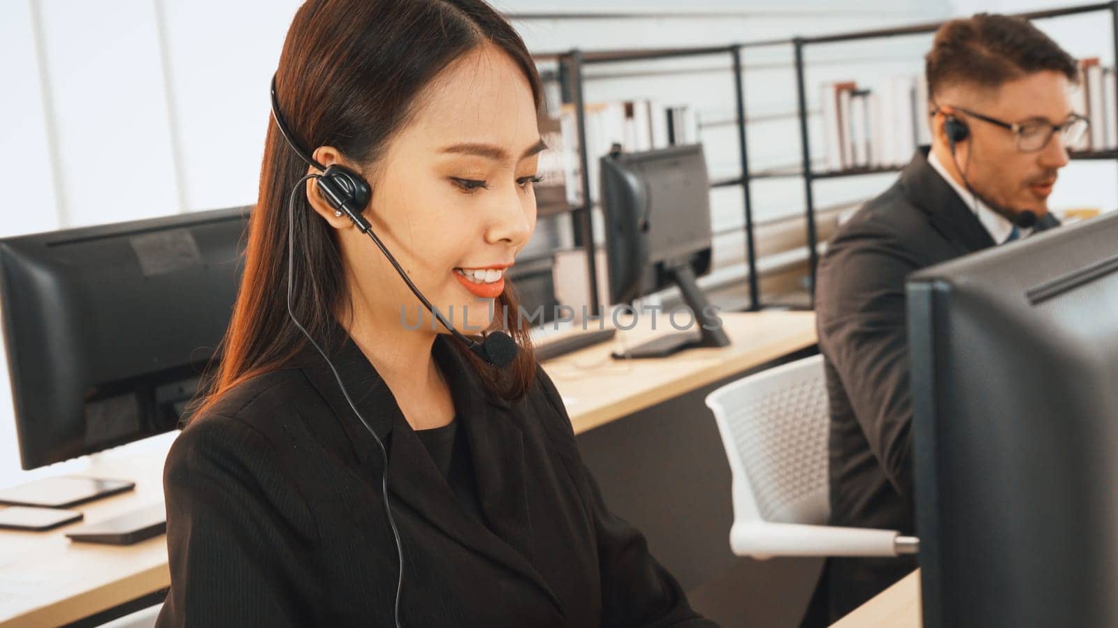 Business people wearing headset working in office to support remote customer or colleague. Call center, telemarketing, customer support agent provide service on telephone video conference call. Jivy