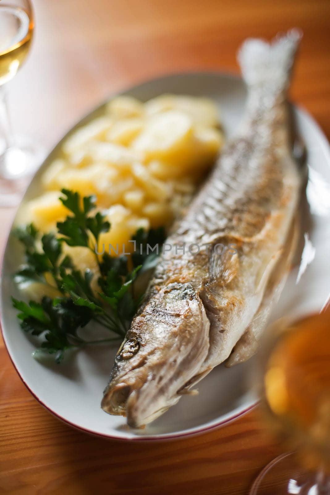Roasted trout with potatoes and parsley close up