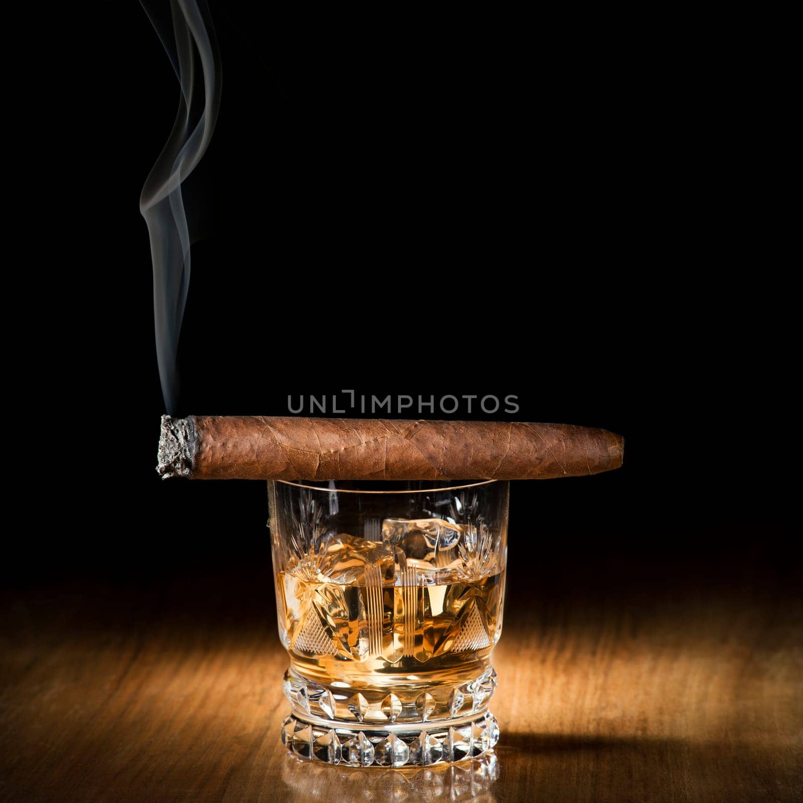 Whiskey and cigar on wooden background close up
