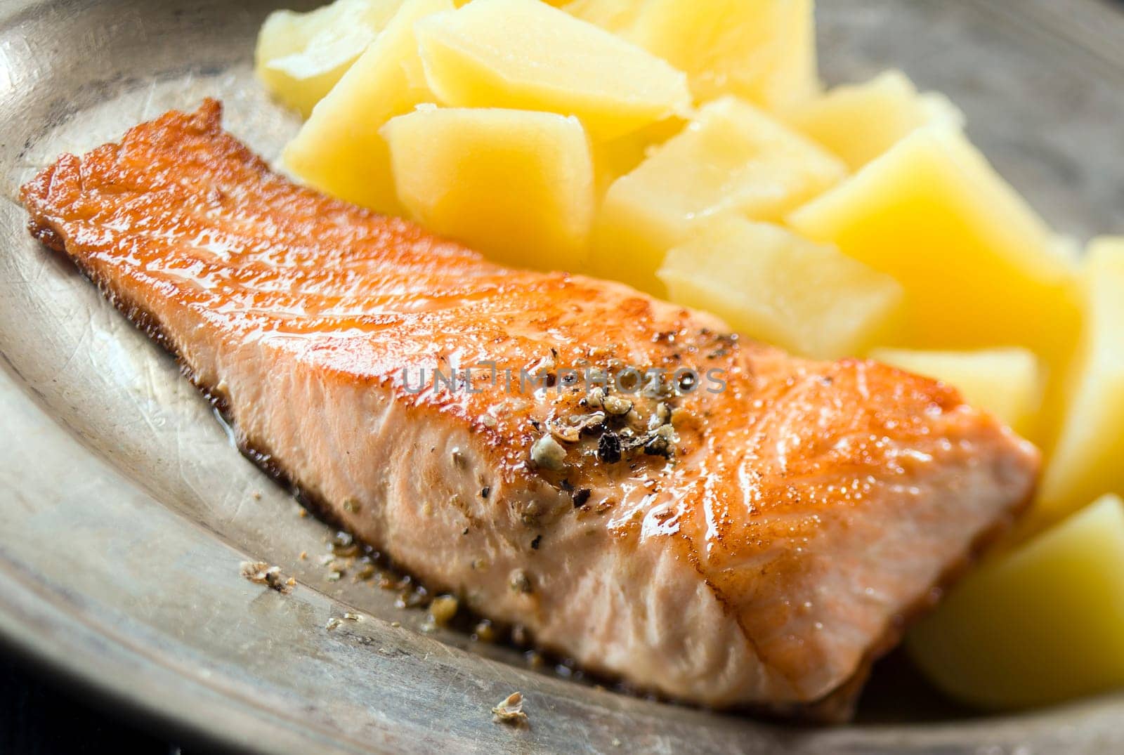 Grilled salmon with boiled potatoes close up