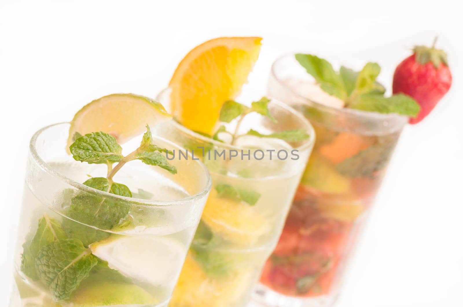 Colorful Mojito cocktails in a row over white background