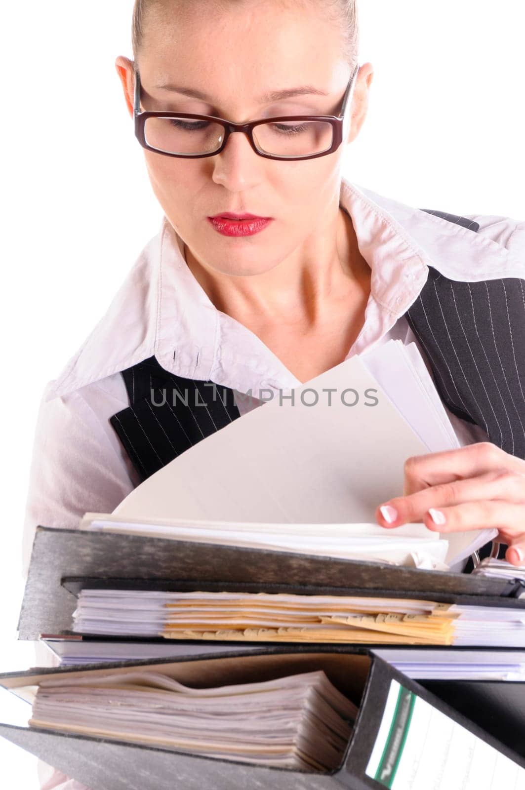 Young woman with blond hair in a business suit (tax consultant,manager,secretary) with skirt and high heels carries a stack of files against a white background.