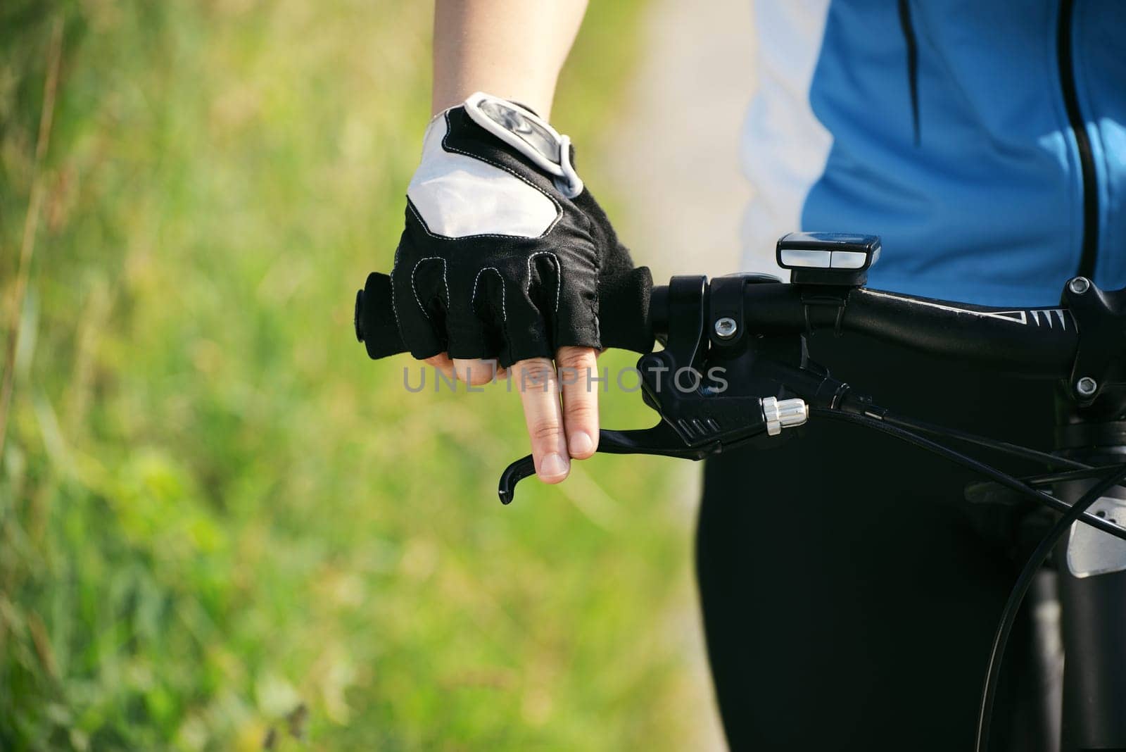 young woman training on mountain bike and cycling in park. Copy space, cropped view