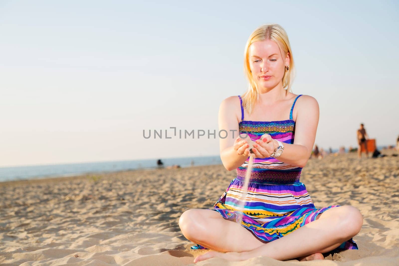 Woman in dress traverse the sand by hands