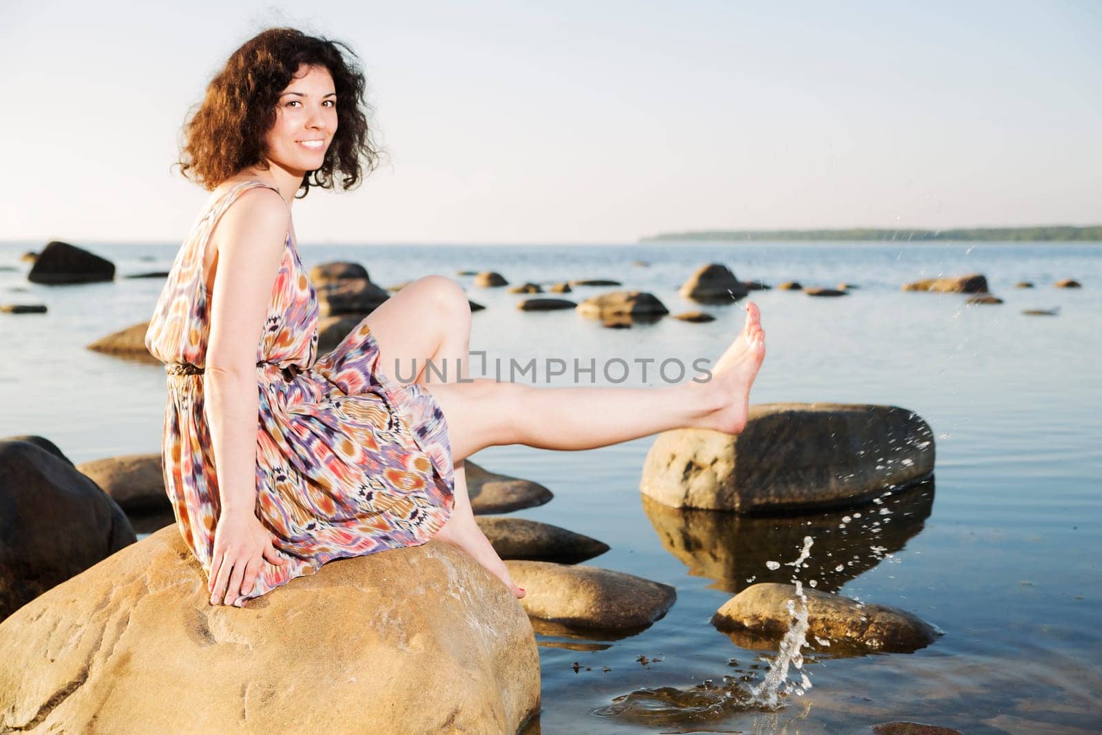 Barefoot woman squirts water drops with shaven leg