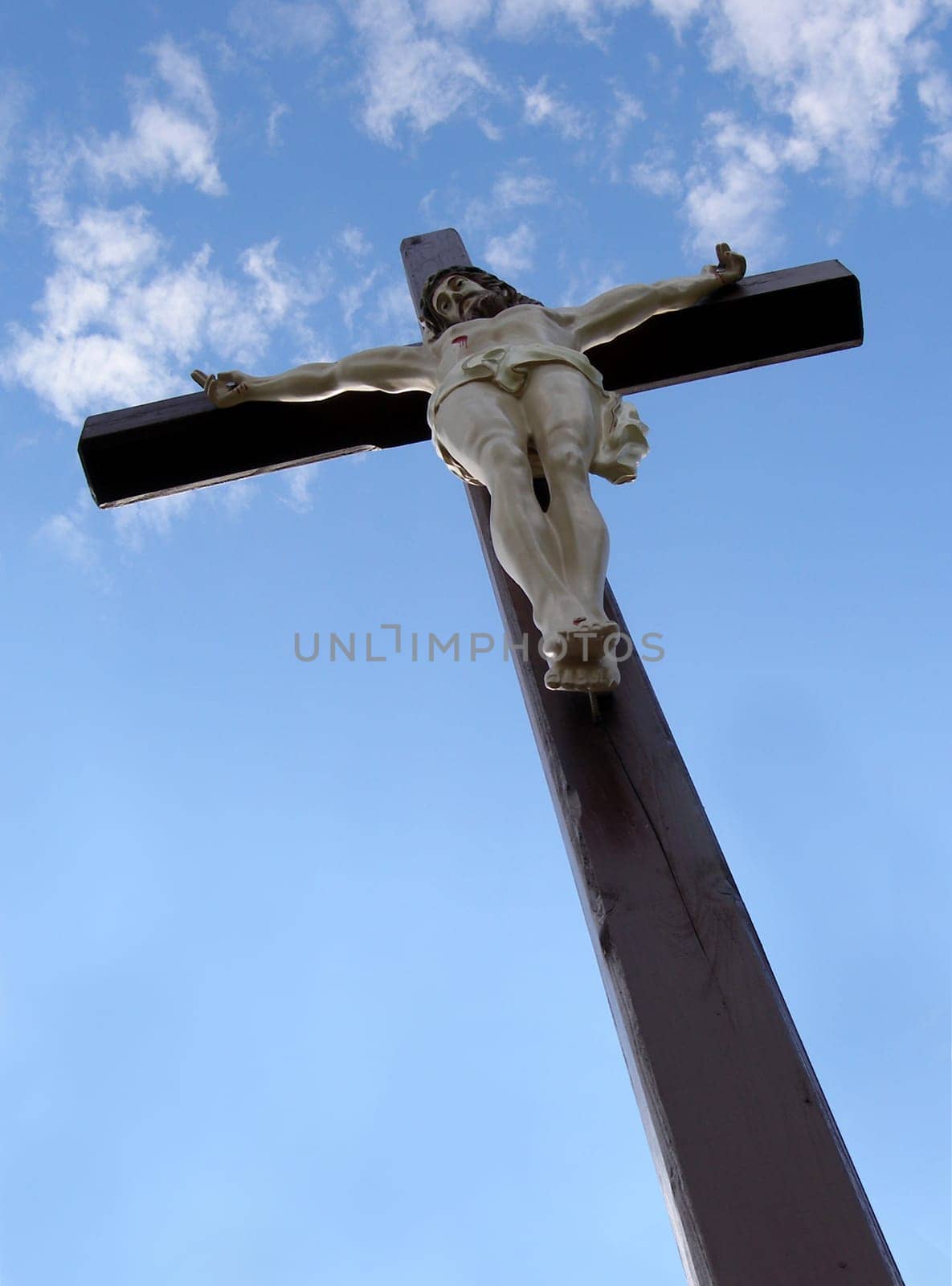 Wooden cross with Jesus Christ with blue sky in background