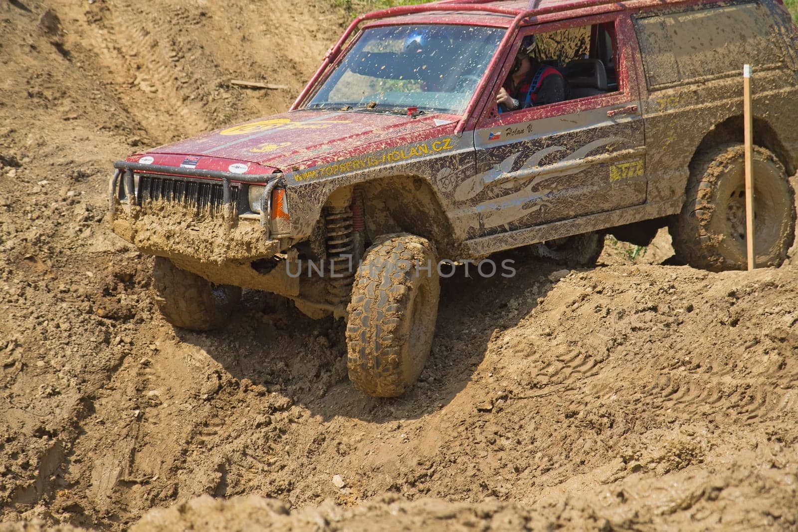 MOHELNICE, CZECH REPUBLIC - JUNE 09. Red off-road car on a steep slope in the "BIG SHOCK CUP Trial 2013"" on June 09, 2013  in the town of Mohelnice, Czech Republic."