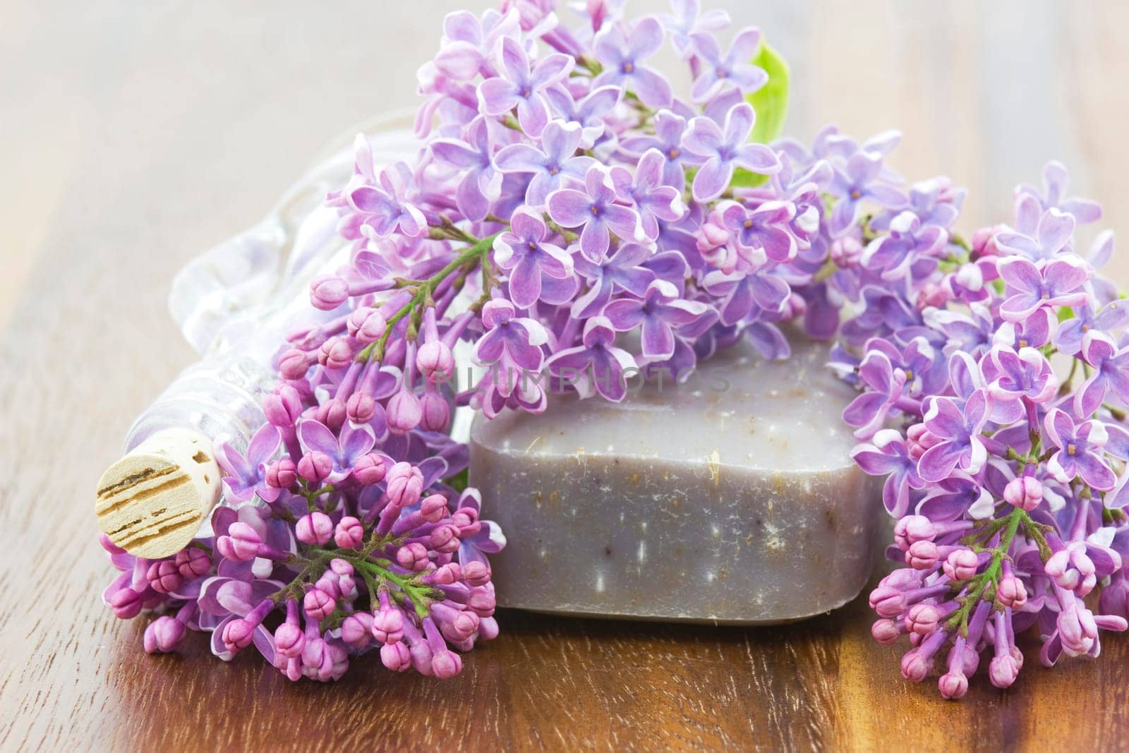 bar of natural soap, bath salt and lilac flowers