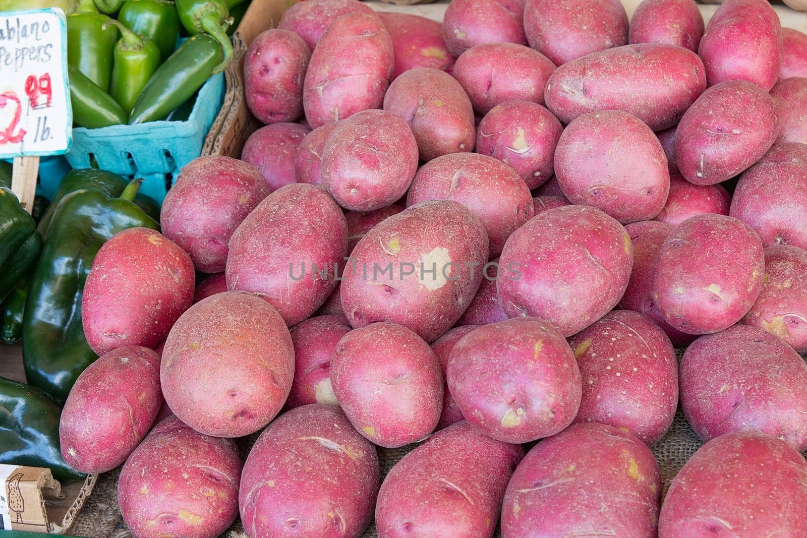 Red Skin Potatoes Display next to Chili Peppers at Farmers Market Fruits and Vegetables Stall