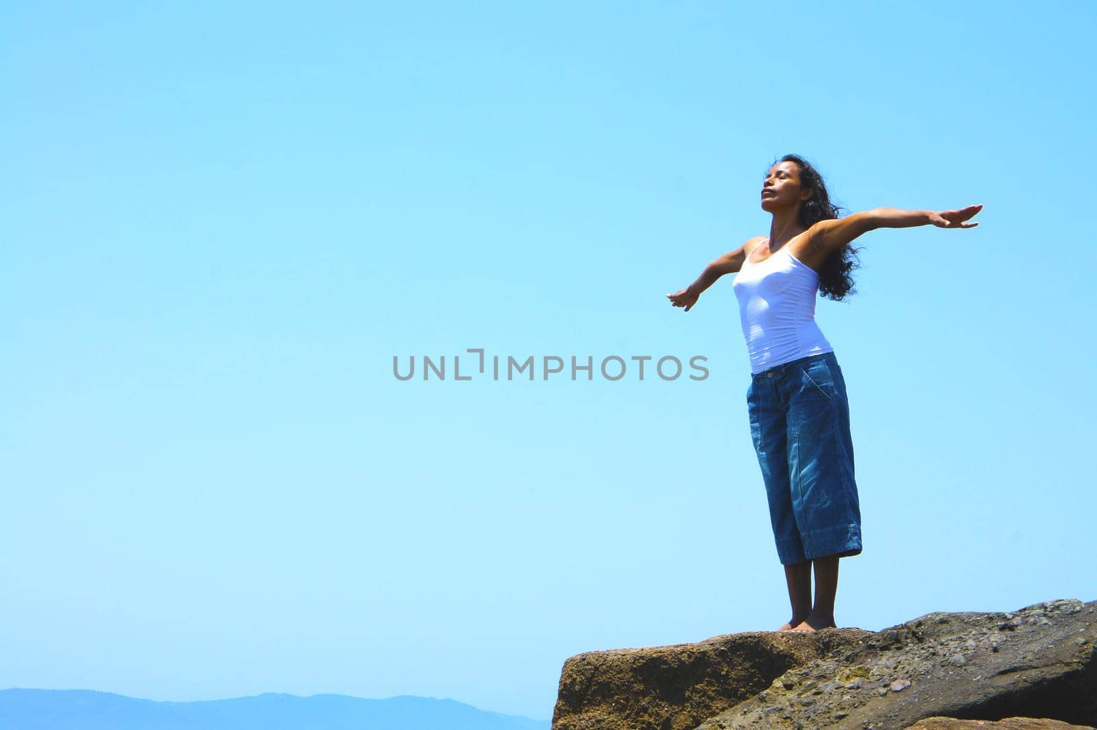 Latina woman practicing yoga on the beach