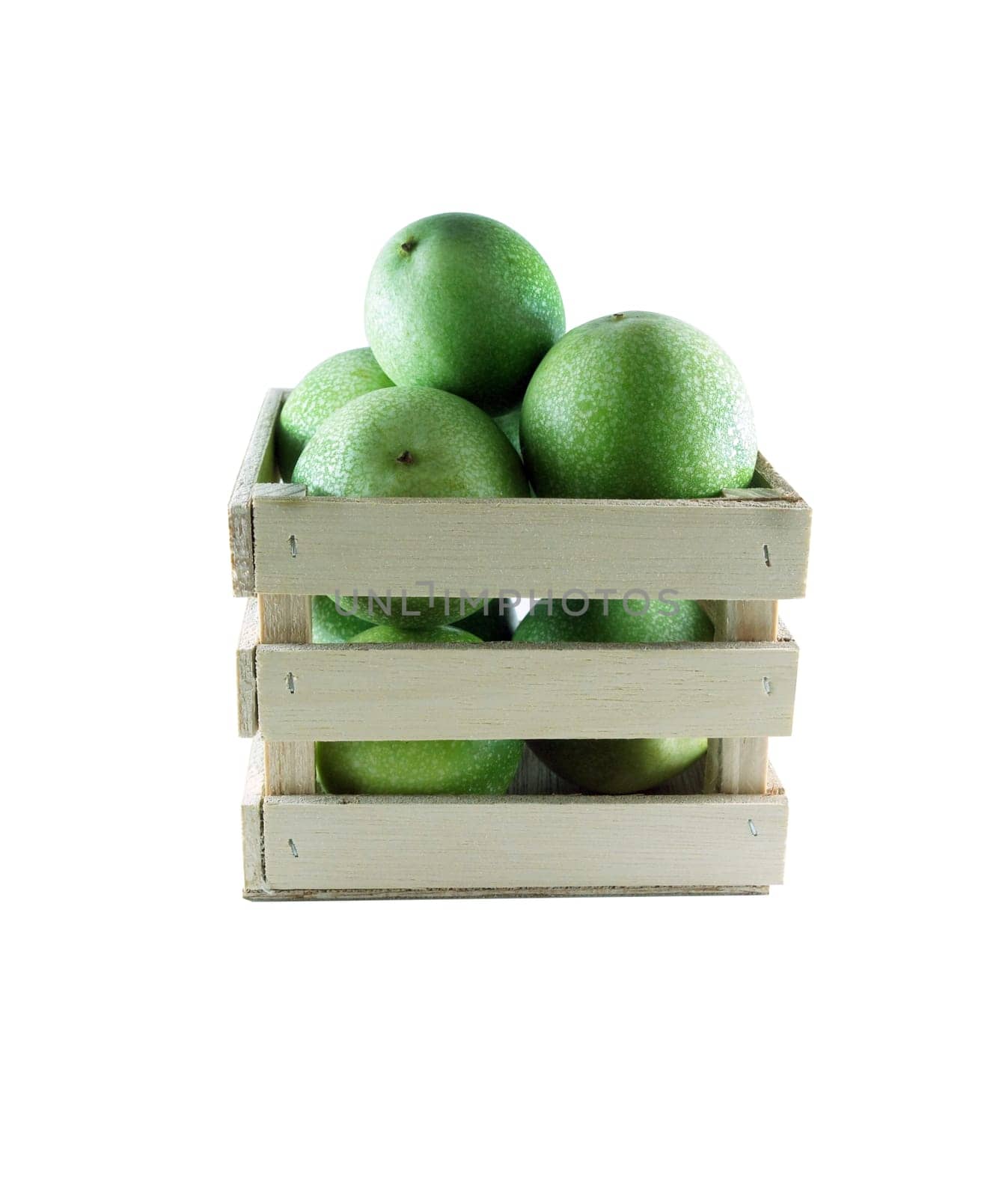 Green pomegranates in a wood box on white background.