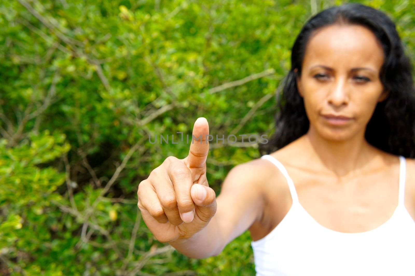 Young latin woman pointing with a finger in the air.