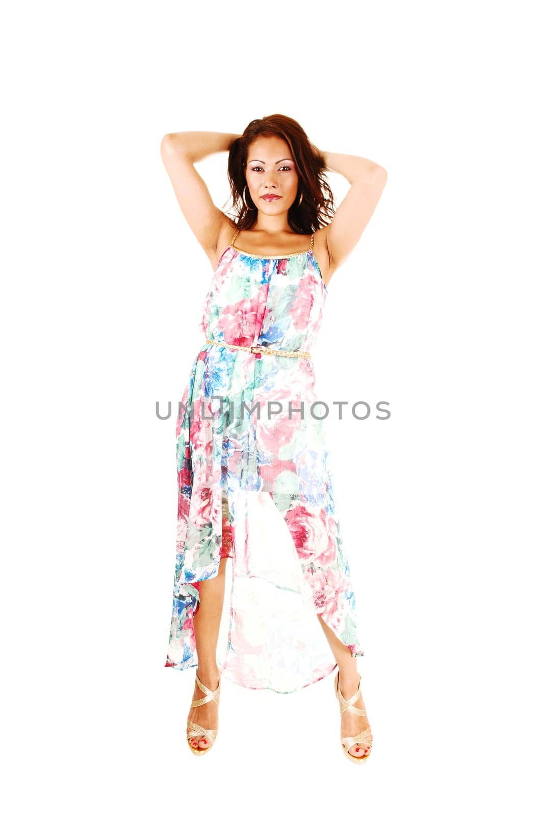 A beautiful native Canadian woman standing in a long colorful summer dress.for white background, having her hands behind her head..