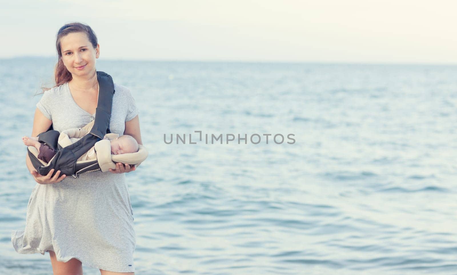 Young mother with baby on the beach