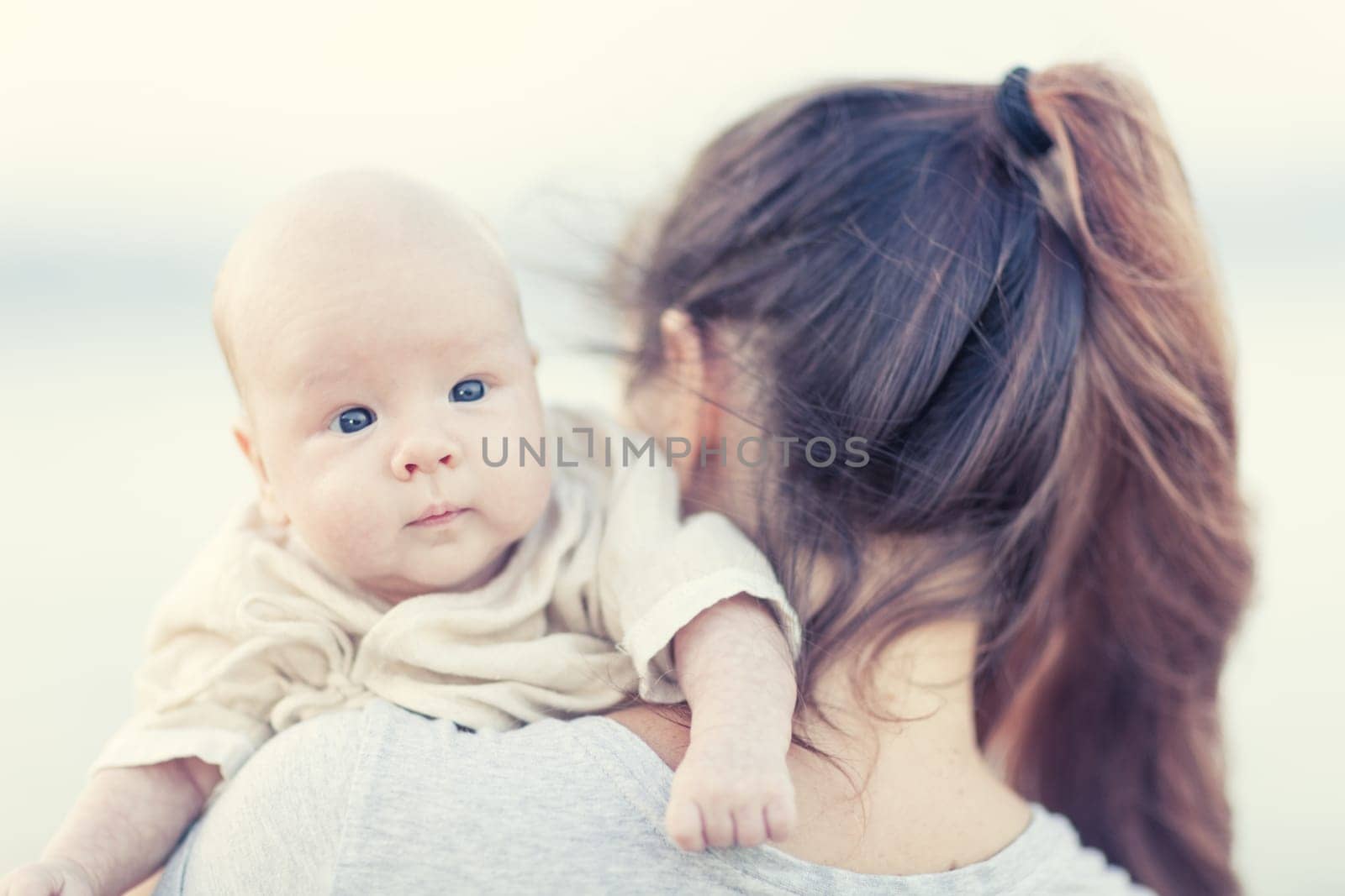Young mother with baby on the beach