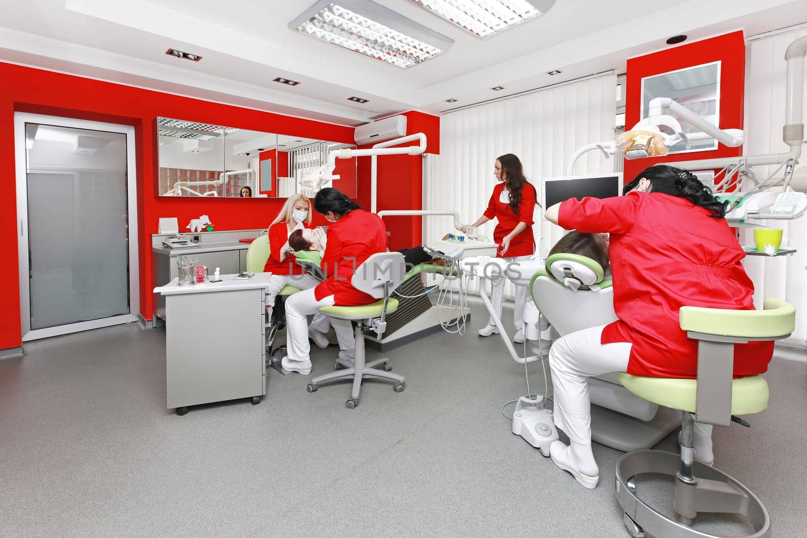 Dentists at work in modern red dental office