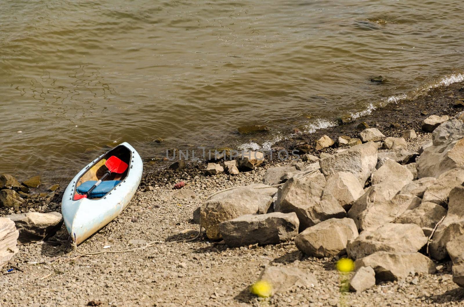 Canoe sitting next to the shore of the Willamette River in Portland, Oregon