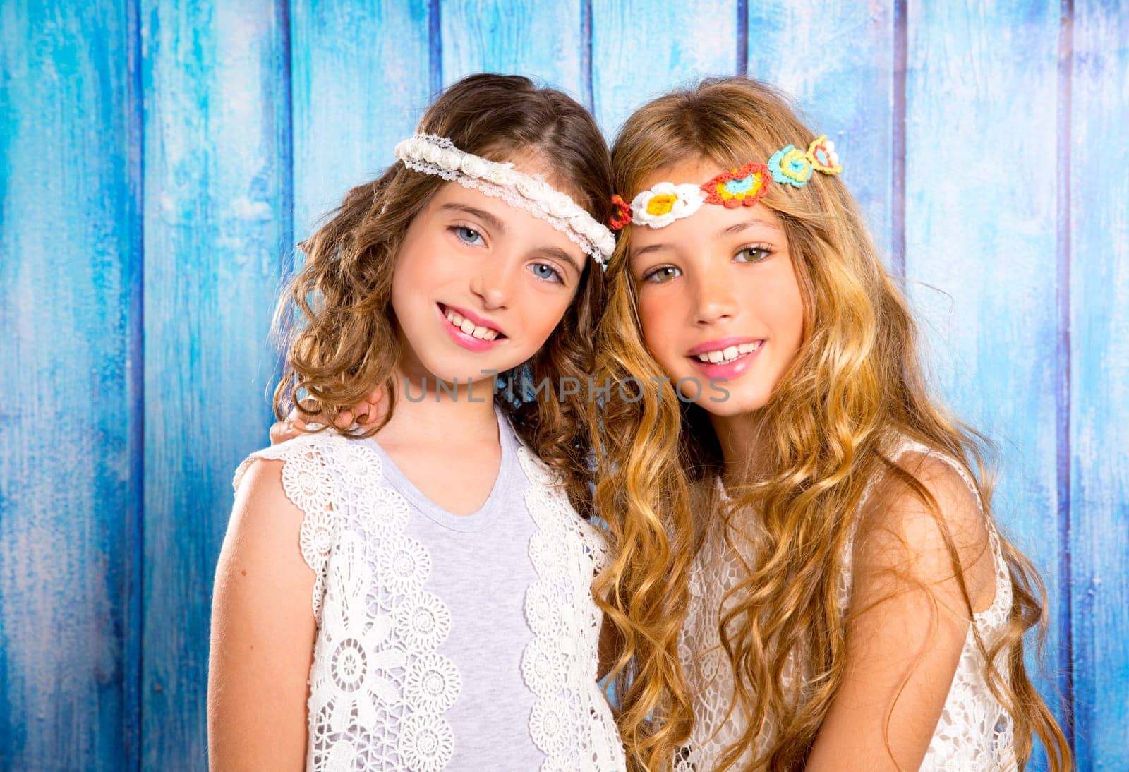 Children friends beautiful girls hippie retro style smiling together on blue wood