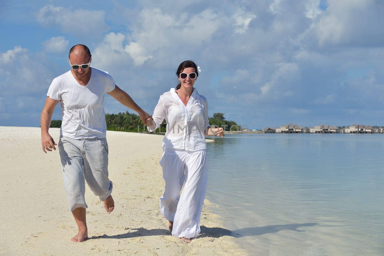 happy young couple have fun and relax at summer vacation on background maldives travel location and beautiful white sand beach
