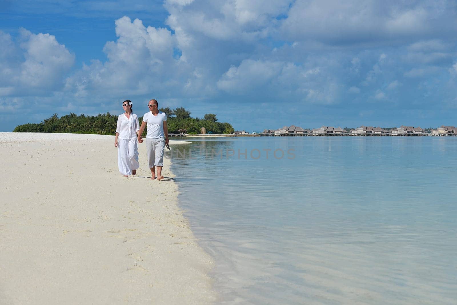 happy young couple have fun and relax at summer vacation on background maldives travel location and beautiful white sand beach