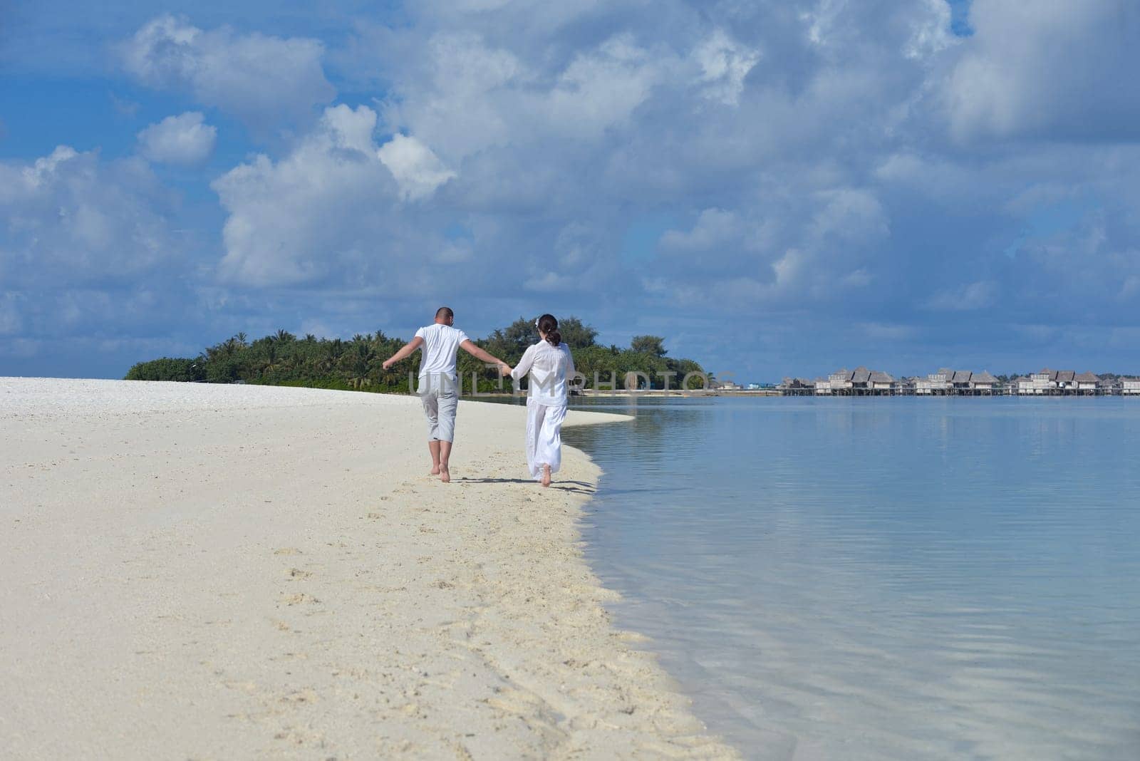 happy young couple have fun and relax at summer vacation on background maldives travel location and beautiful white sand beach