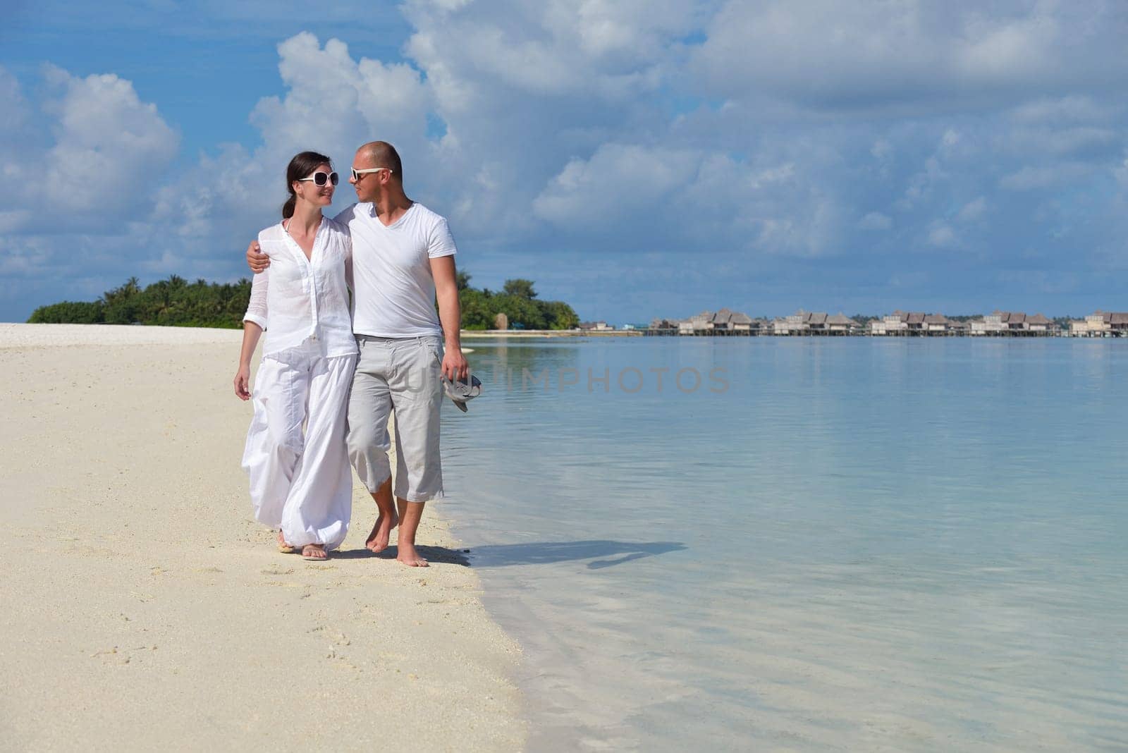 happy young couple have fun and relax at summer vacation on background maldives travel location and beautiful white sand beach