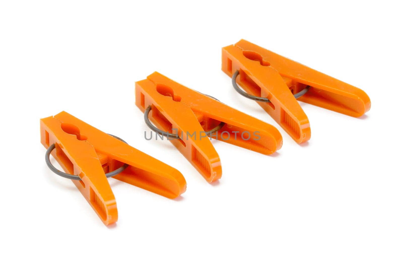 Orange plastic clothespins on white background