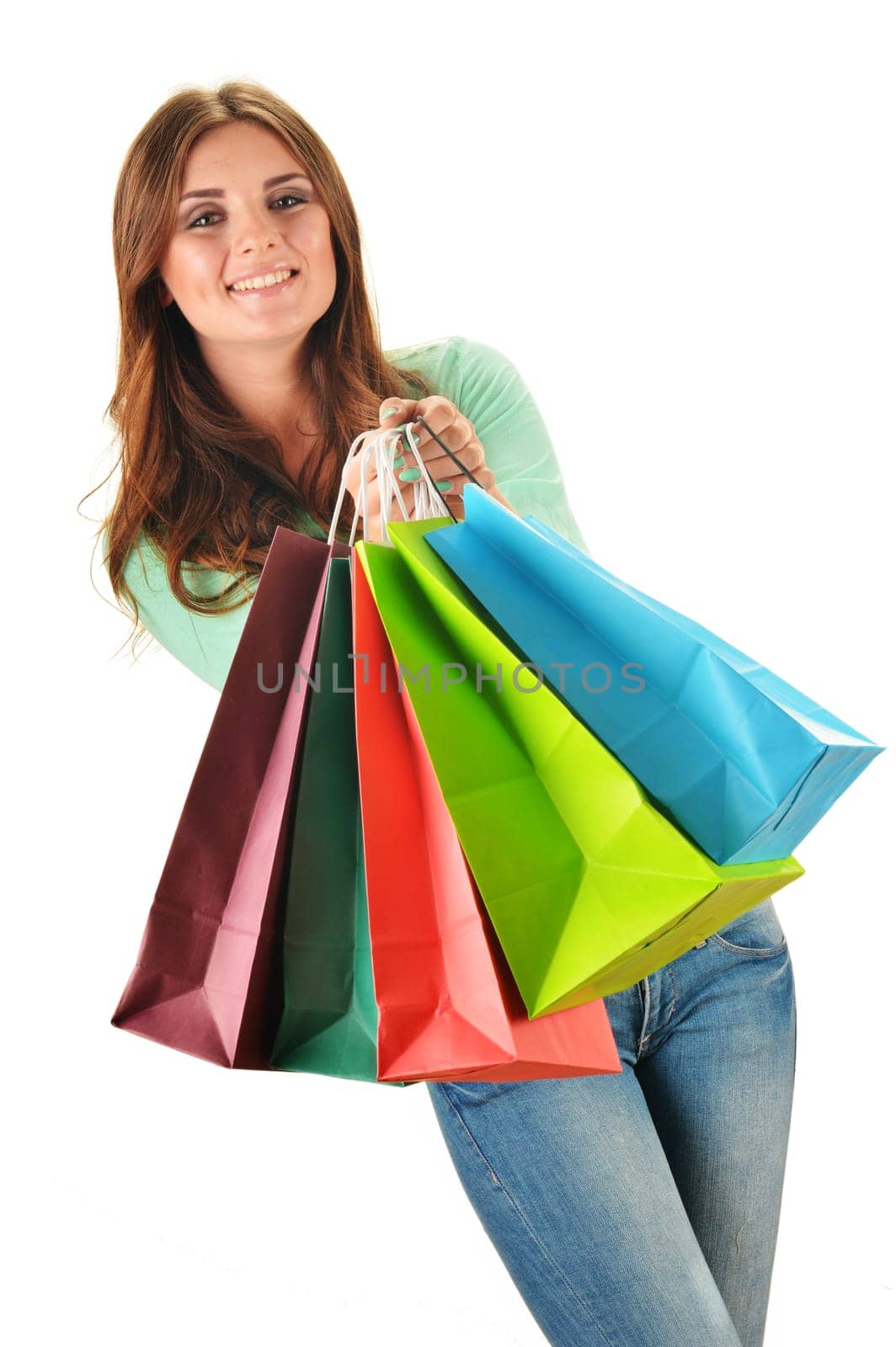 Young happy woman with colorful paper shopping bags isolated on white