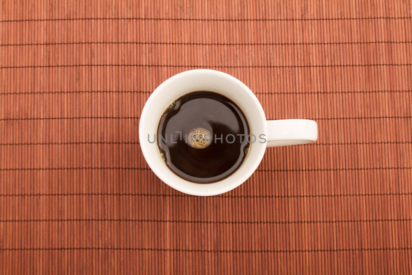 A steamy cup of coffee on a placemat.