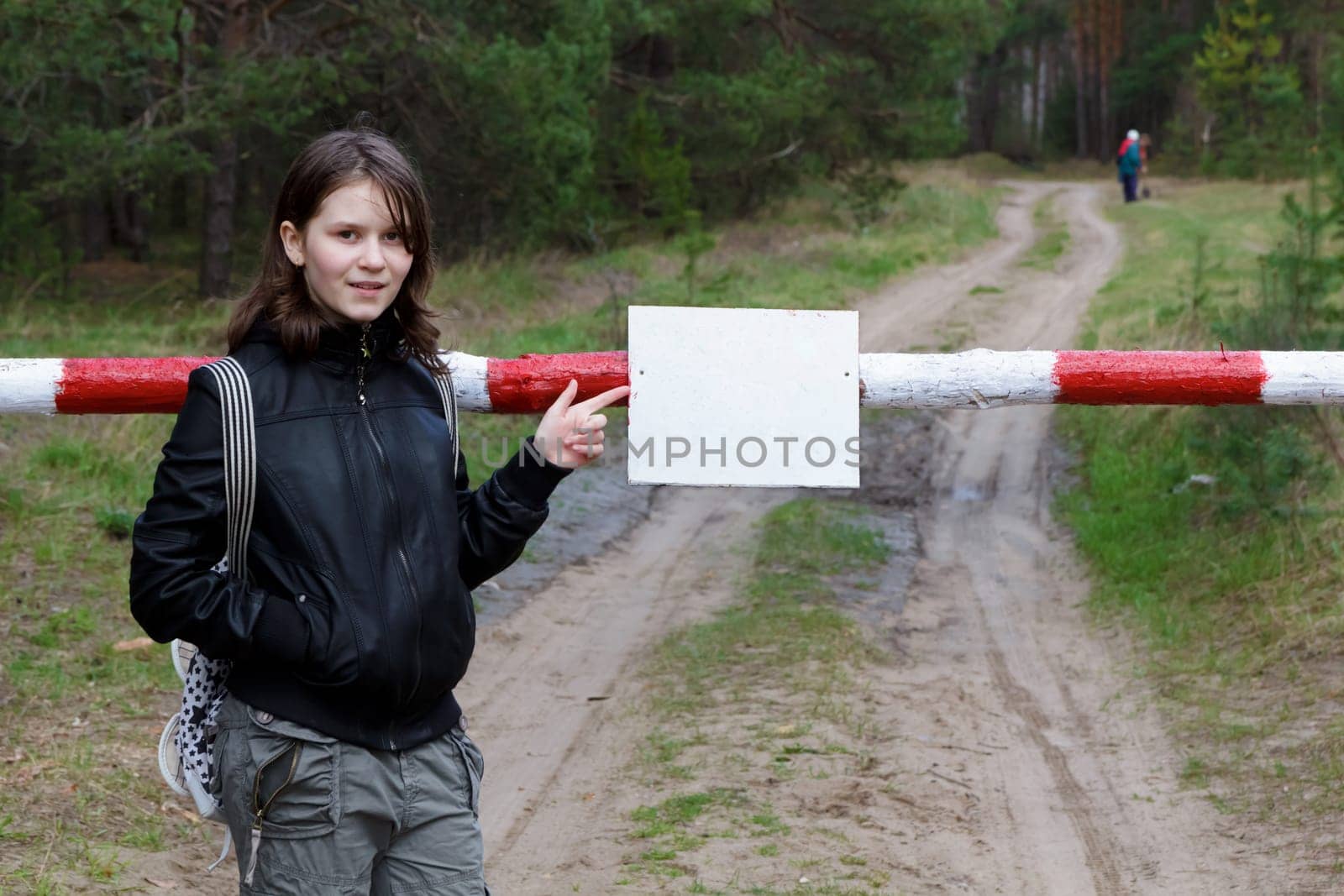 teen girl points to sign on the barrier