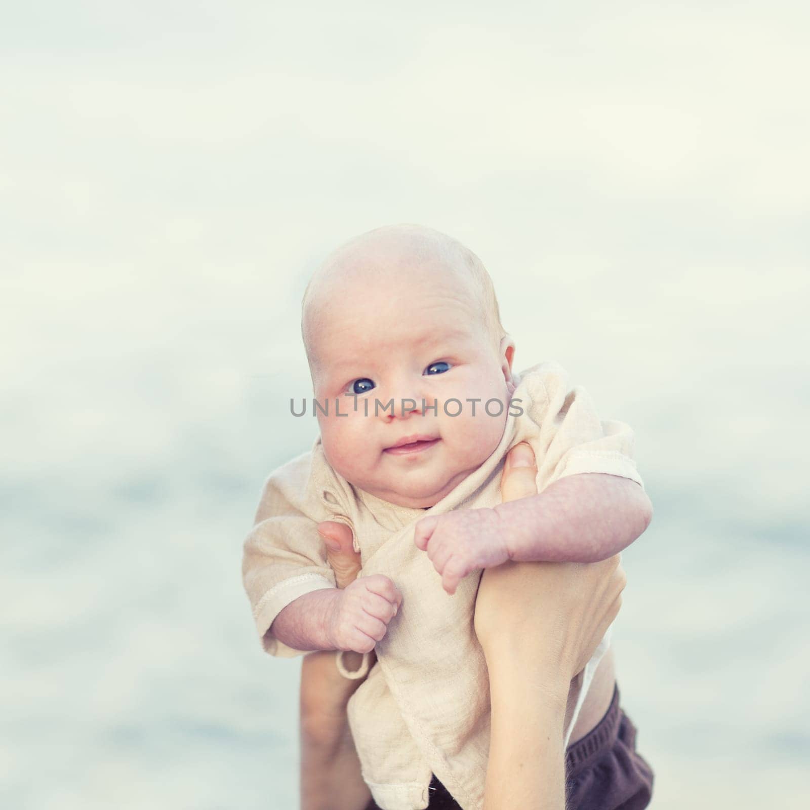 Human hands are holding adorable baby