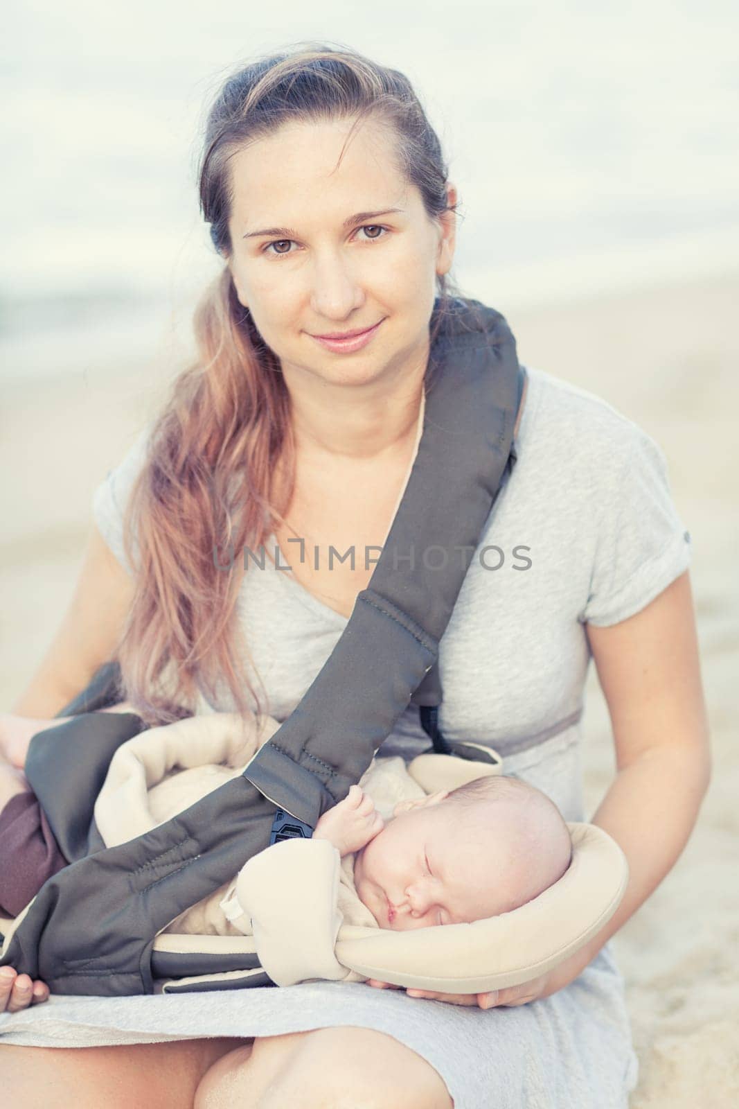 Young mother with baby on the beach
