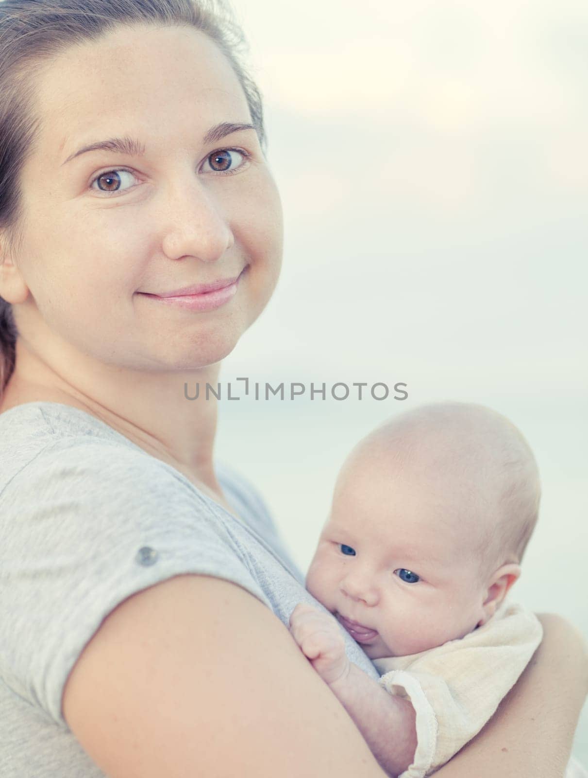 Young mother with baby on the beach