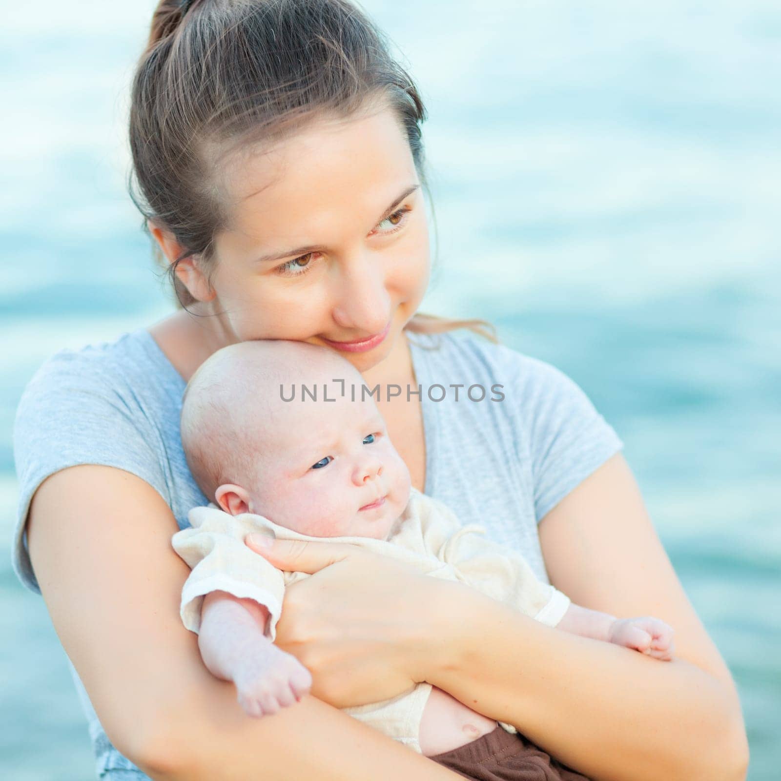Young mother with baby on the beach