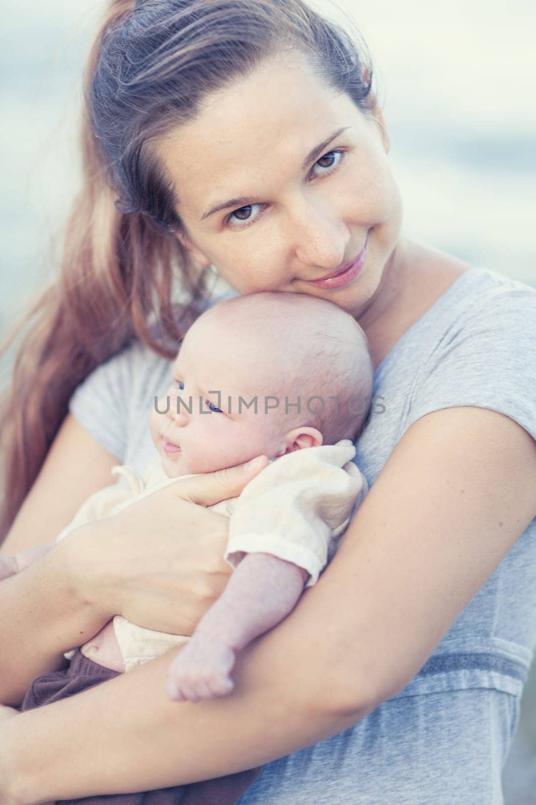Young mother with baby on the beach
