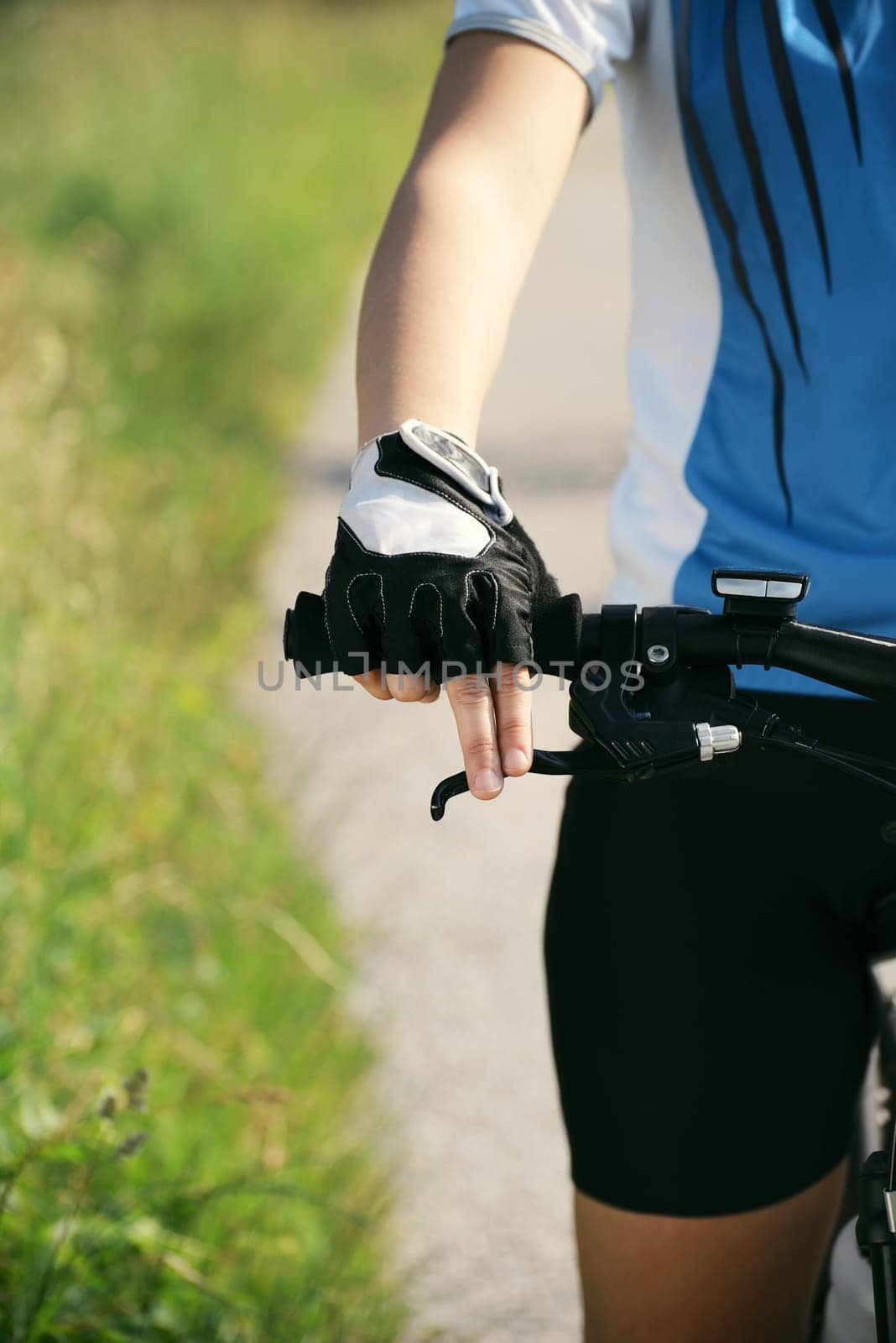 young woman training on mountain bike and cycling in park. Cropped view