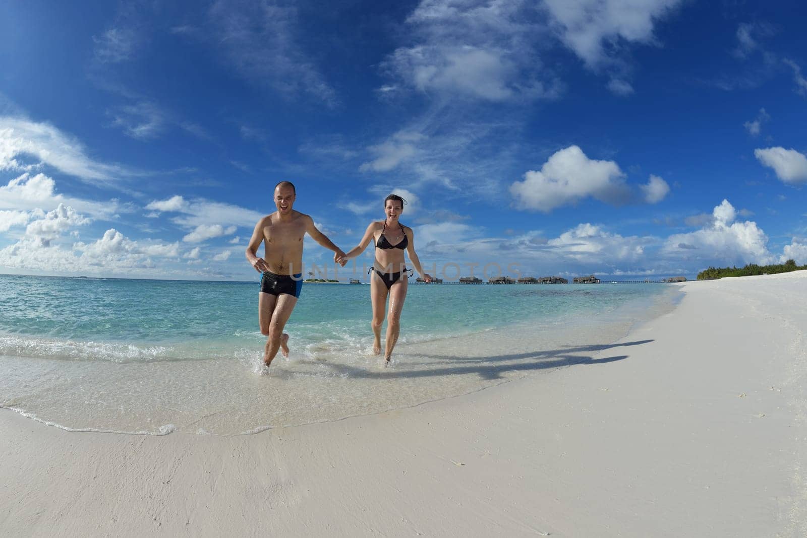 happy young couple have fun and relax at summer vacation on background maldives travel location and beautiful white sand beach
