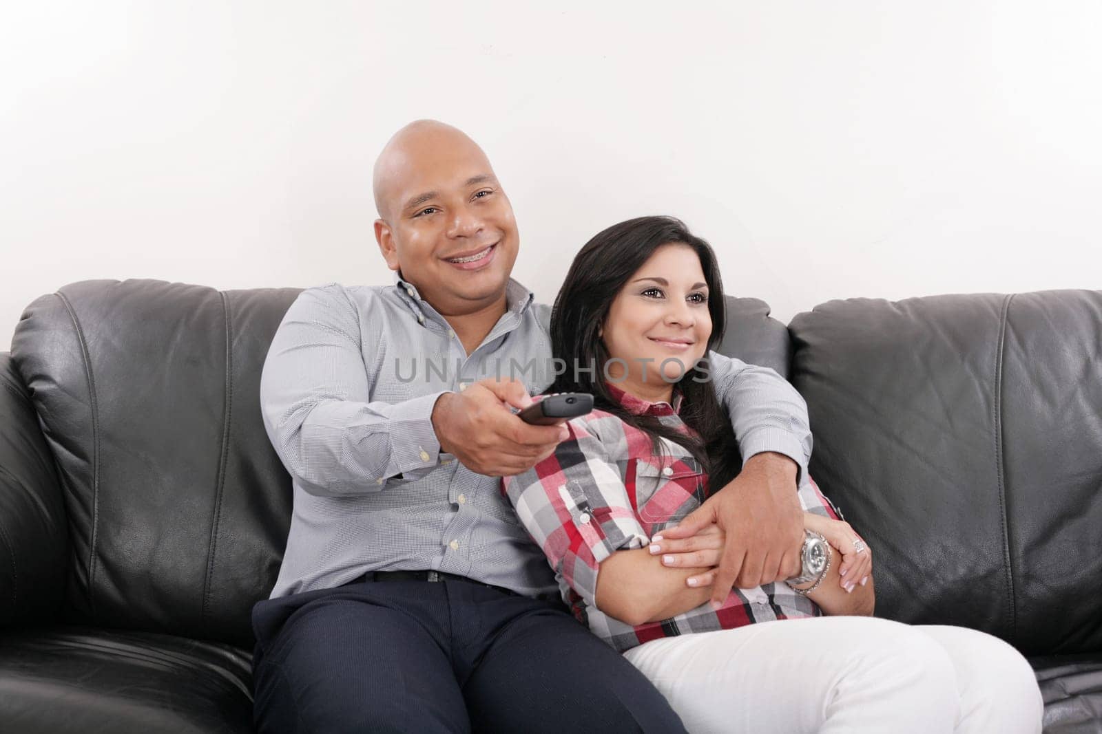 Young couple watching tv on a sofa