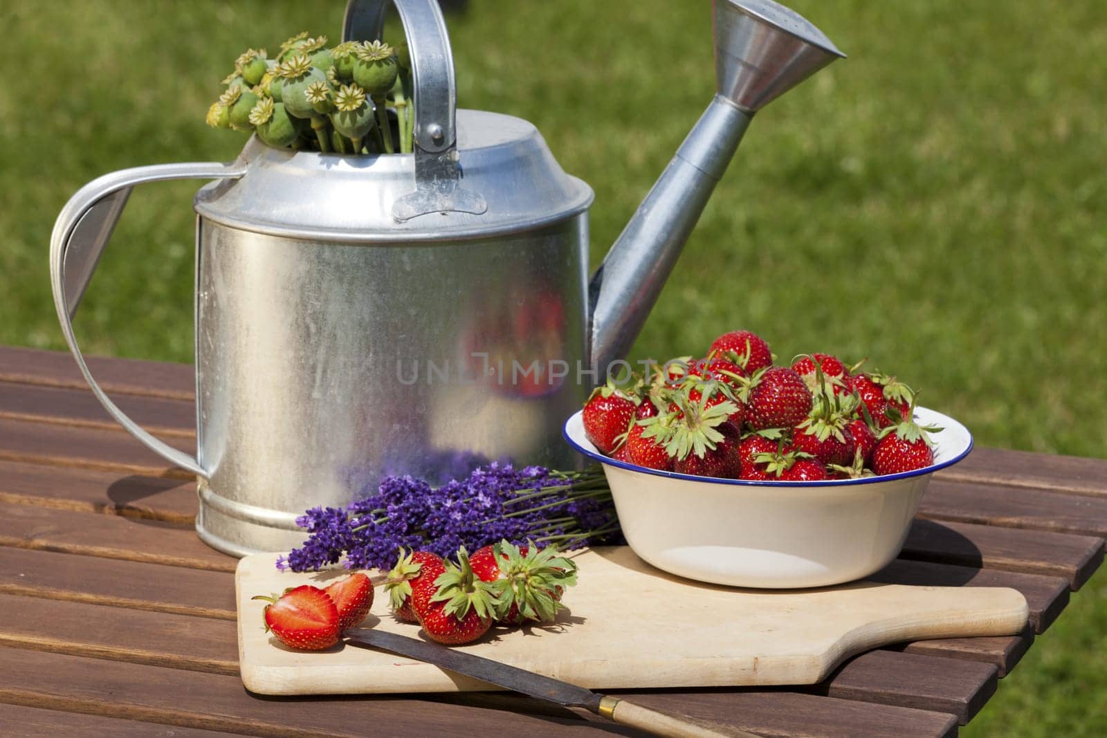 Fresh strawberries,fragrant lavender and poppy seed capsules after harvesting lie on a table