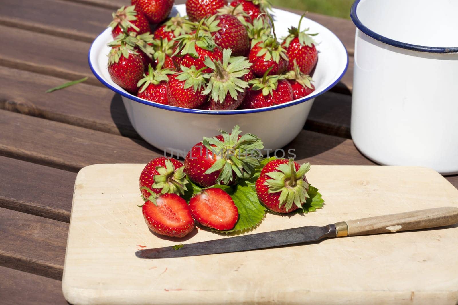 Strawberries,freshly harvested on a cutting board with a knife
