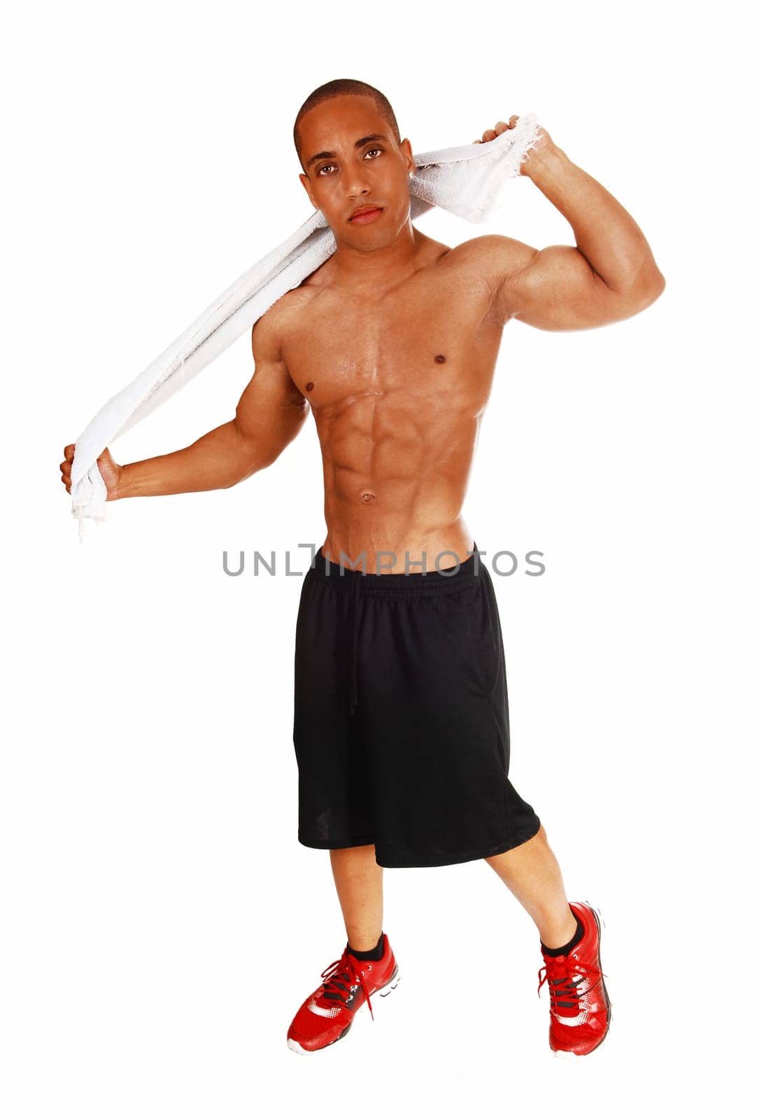 A young muscular man after his exercise rubbing himself dry with a .white towel for white background..