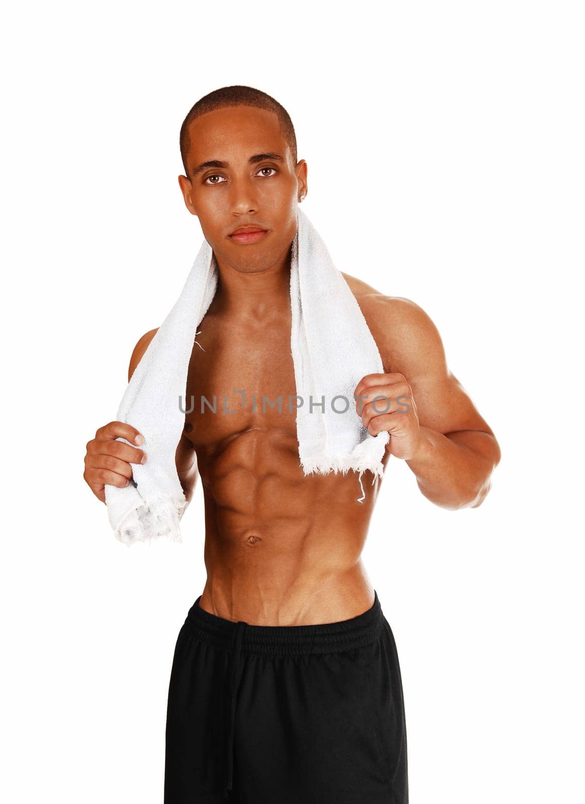 A young bodybuilder after his exercise standing for white background with.a white towel around his neck..