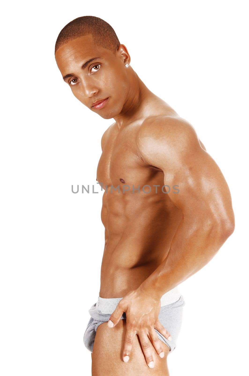 A young muscular bodybuilder in a torso shoot standing in gray underwear.for white background showing his great body..