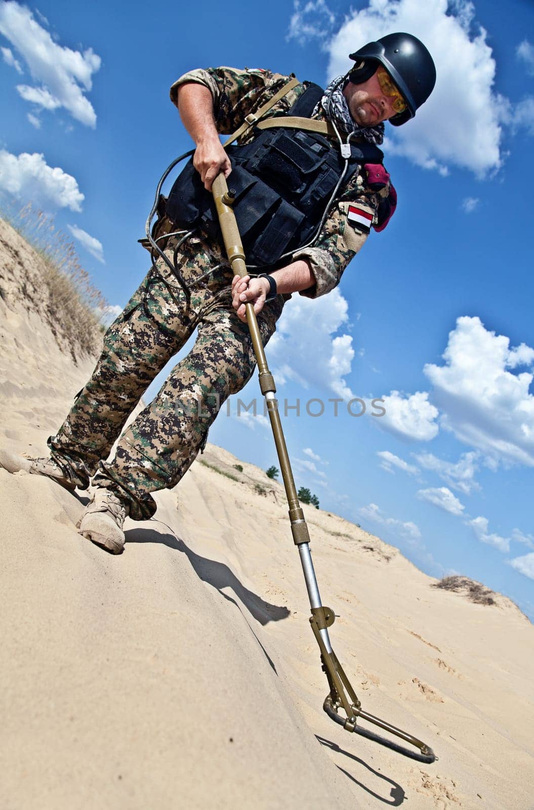 iraqi soldier in the desert with army metal detector