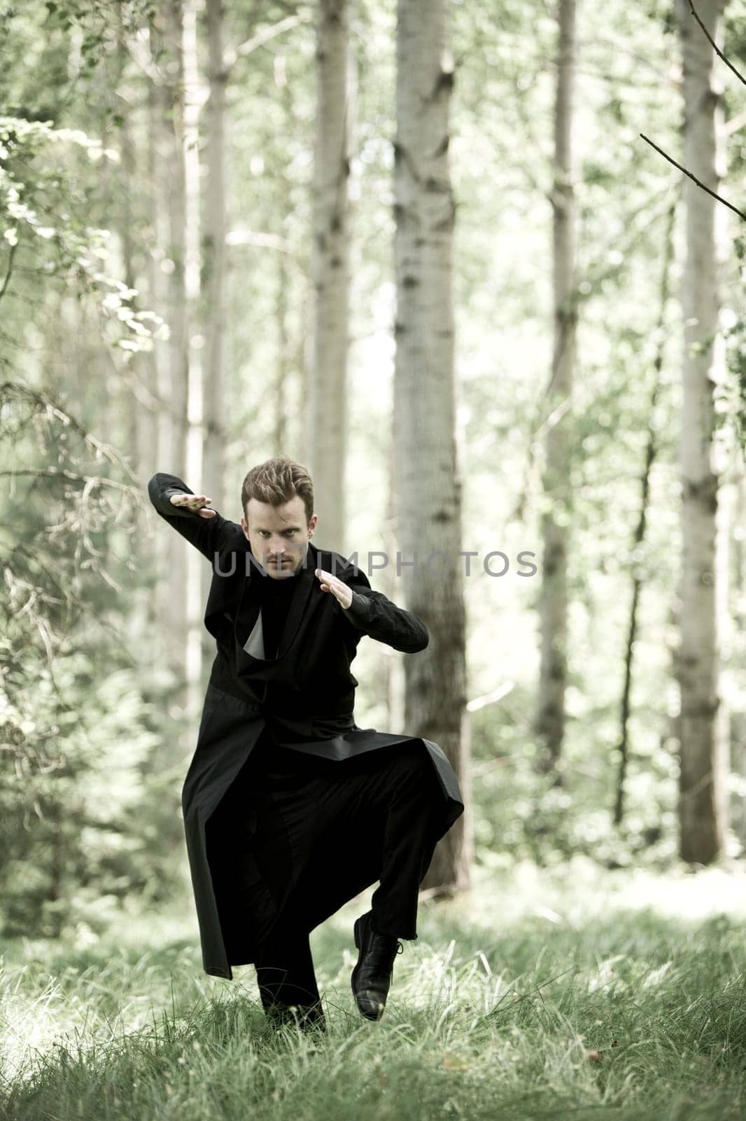 Man with black long coat in the forest