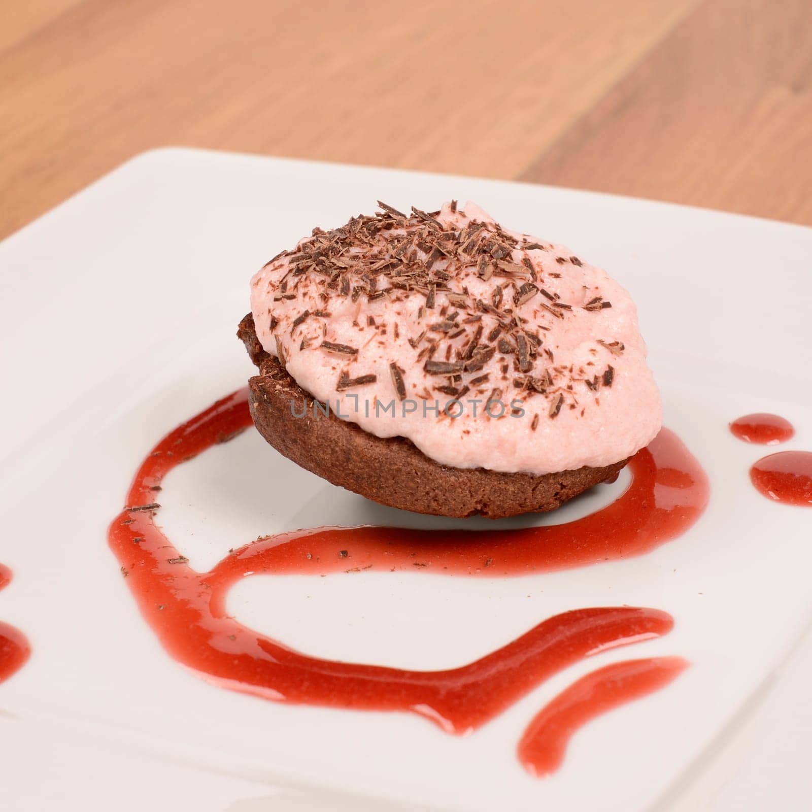 Sweet cake with strawberry cream and chocolate on a plate